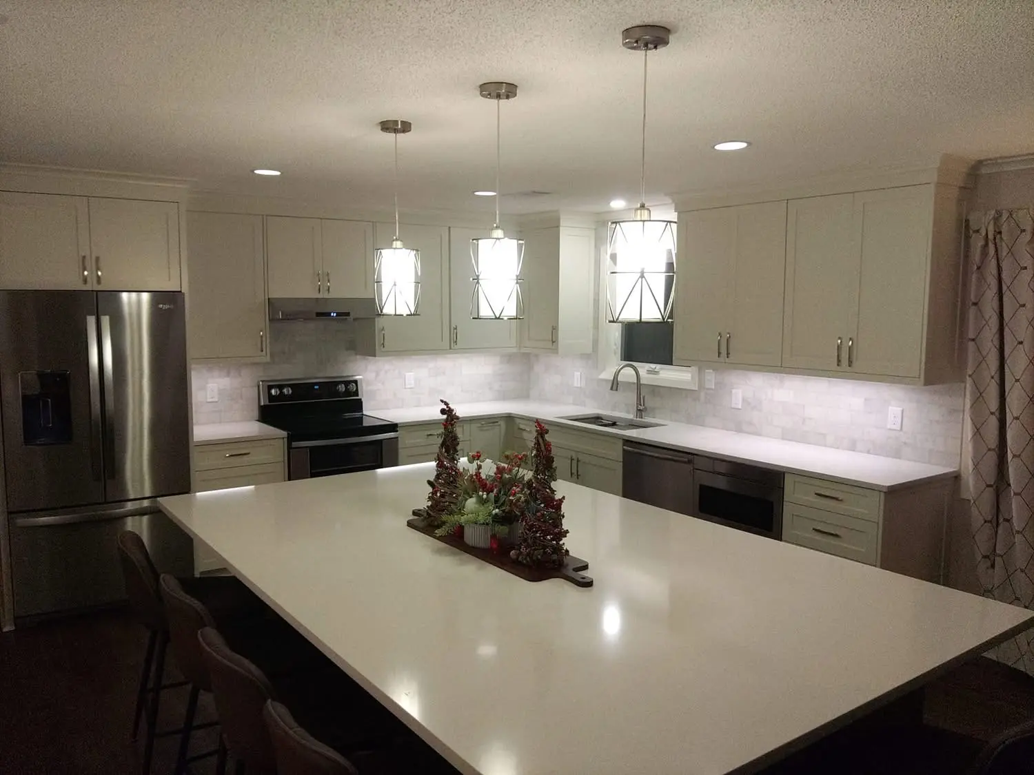 White and green kitchen with lantern pendants